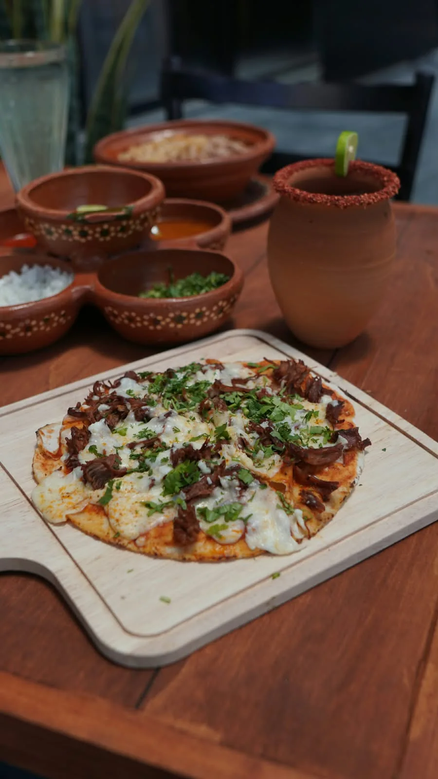 Pizzabirria entera sobre tabla de madera.