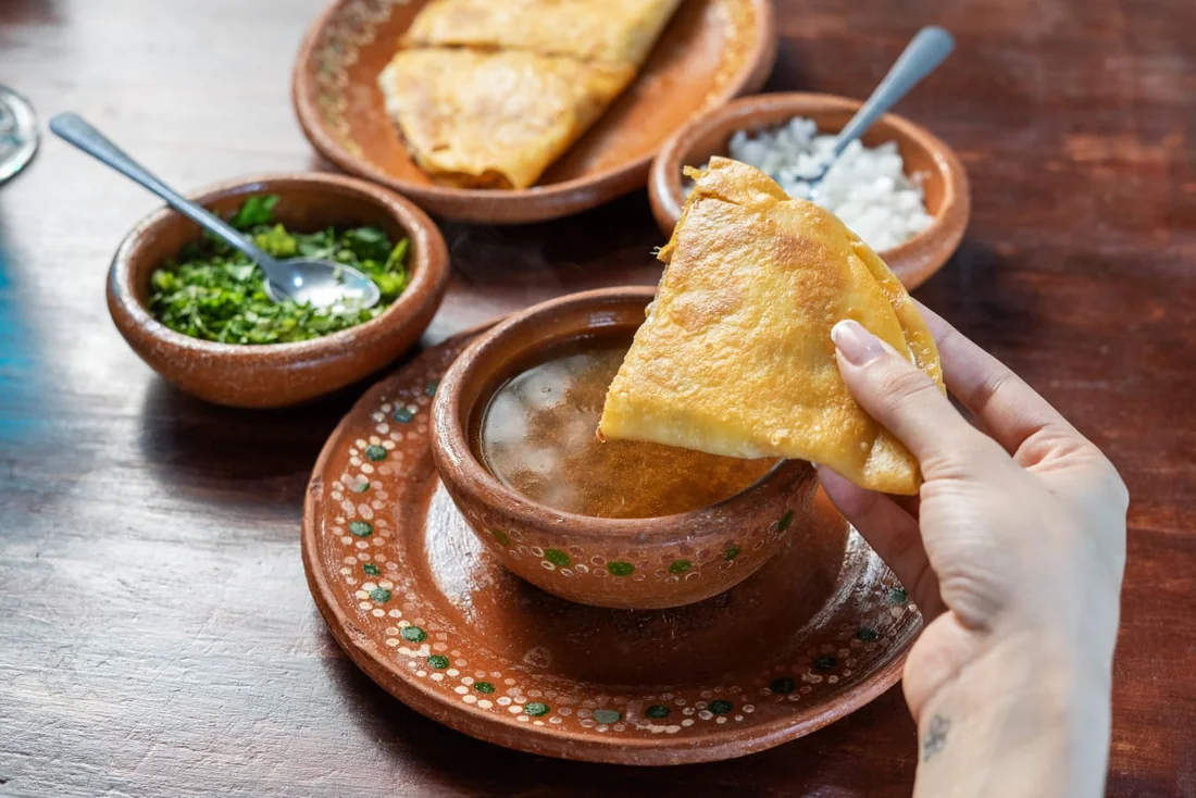 Taco dorado mojado en consomé.