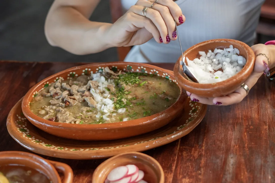 Carne en su jugo con cebolla picada al lado.