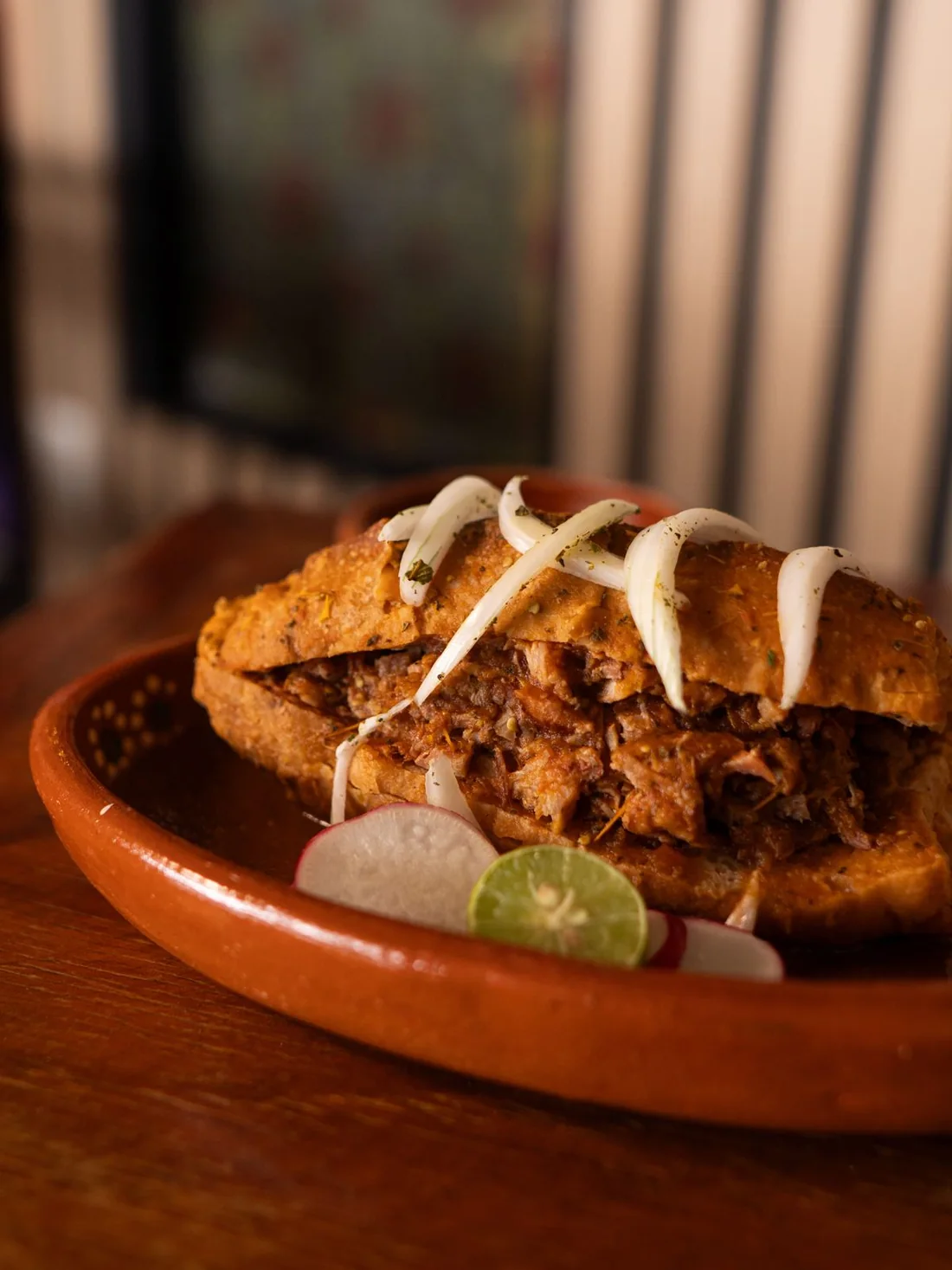 Torta ahogada con cebolla, rábano y limón.