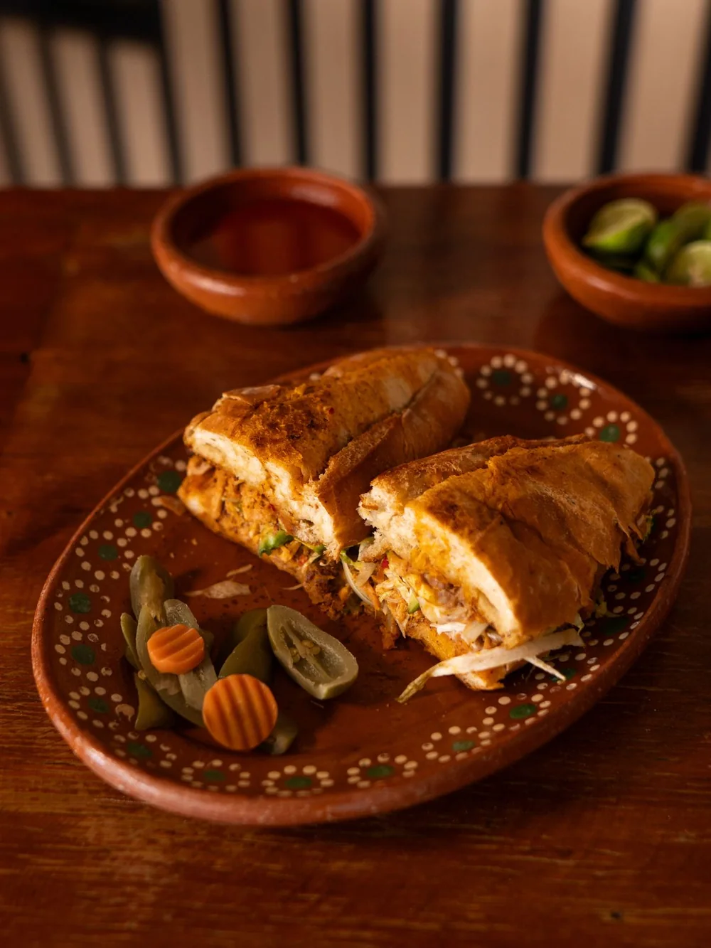 Lonche en birote partido a la mitad, con chiles y zanahorias en vinagre.